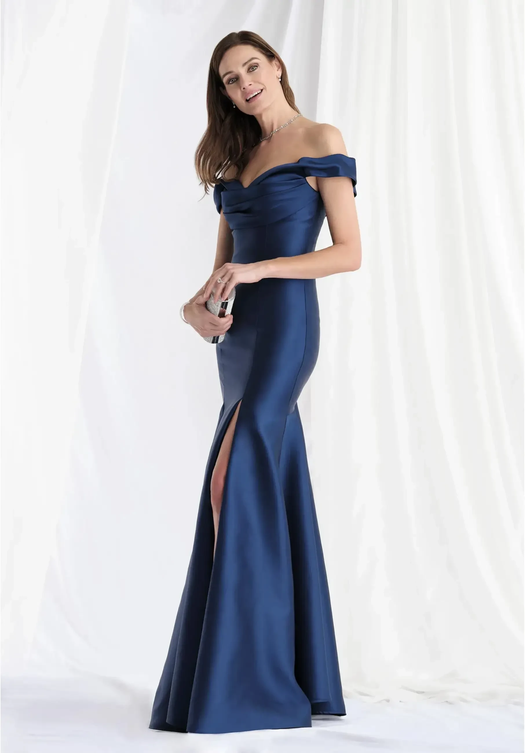 model is wearing a navy blue off the shoulder mother of the bride dress