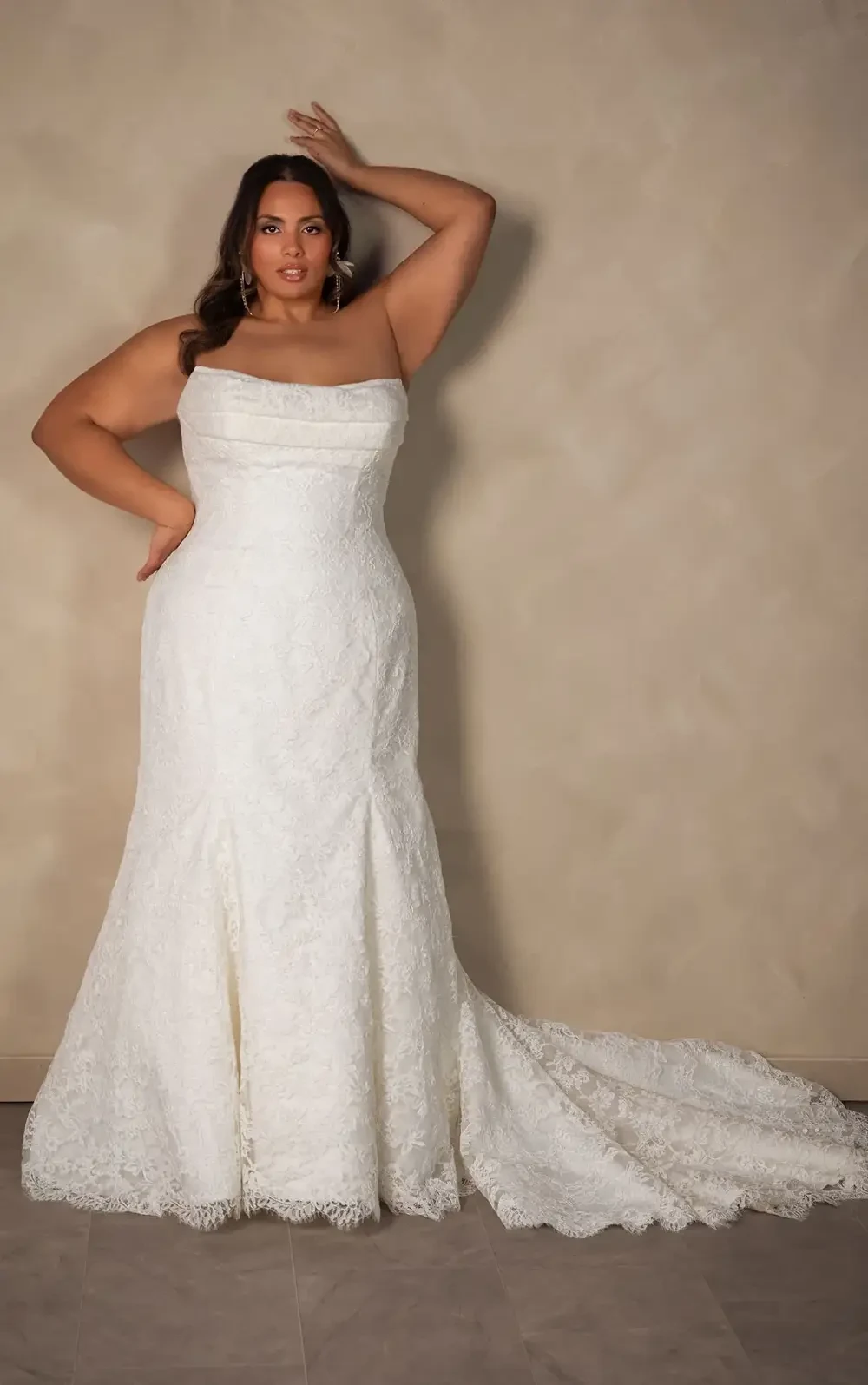 model is wearing a strapless plus size bridal gown