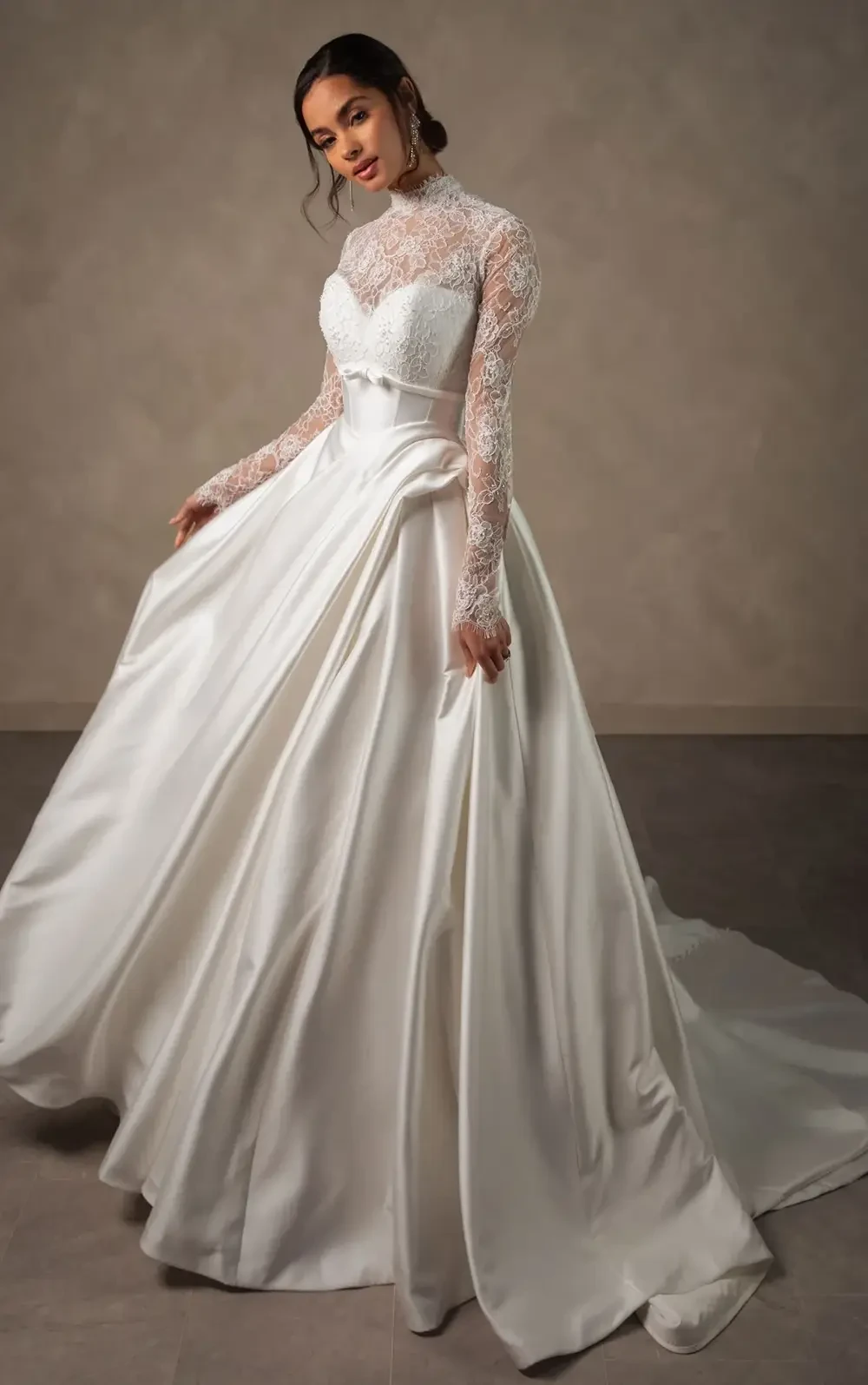 model is wearing a high neckline lace long sleeve bridal gown