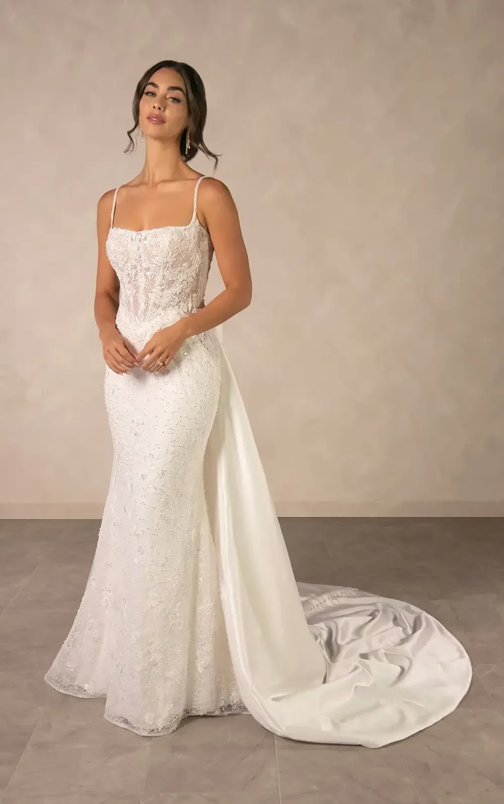 model is wearing a sleeveless spaghetti strap fit and flare wedding dress